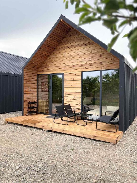 a cabin with chairs and tables on a deck at Slana bara glamping in Slana Bara