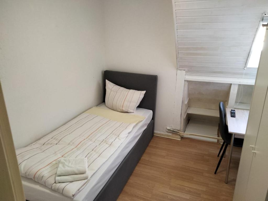 a small bedroom with a bed and a desk at Zentrale 3 Zimmer Unterkunft mit Parkplatz in Neumünster