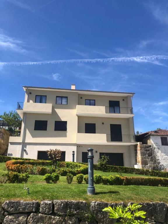 a large white building with a pole in front of it at Casa das Eiras, em Cinfães, no Douro in Cinfães