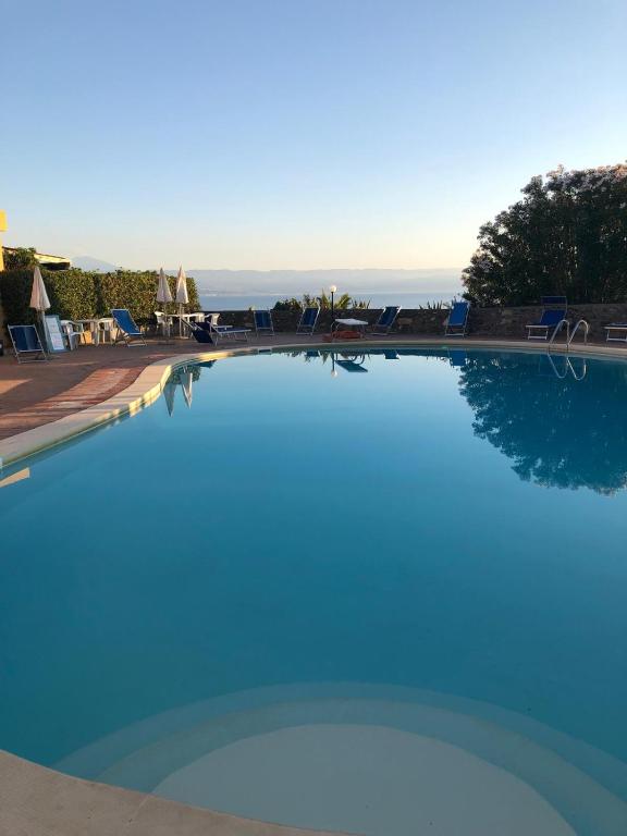 a swimming pool with blue water in a resort at Una Piscina sul Mare Apartment in Milazzo