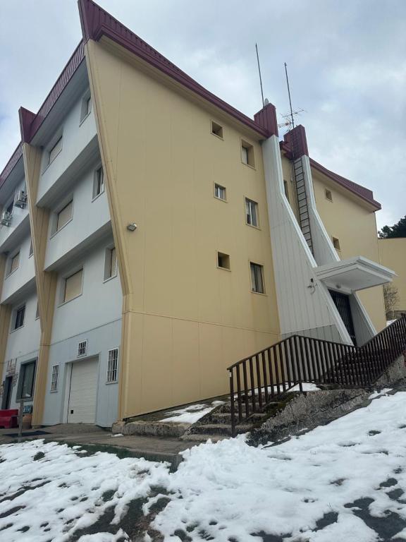 a building with a staircase in the snow at Aral in La Pinilla
