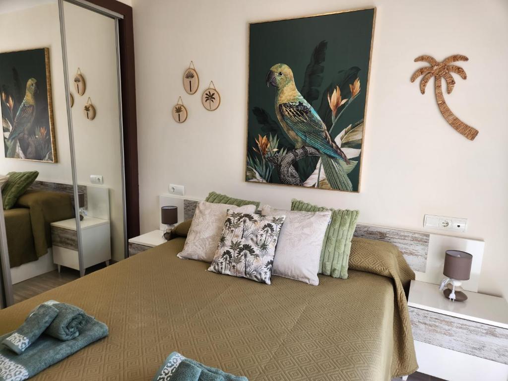 a bedroom with a bed and paintings on the wall at Ático Boutique con Piscina privada en el Solárium y Diseño Natural in Vera