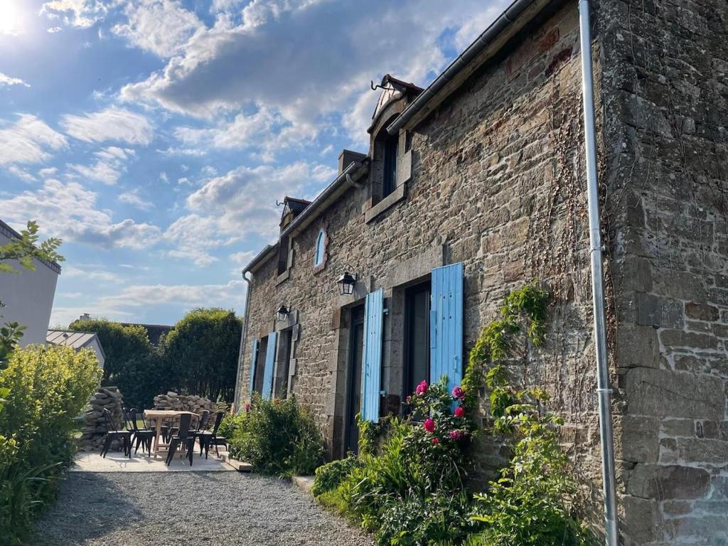 un vieux bâtiment en briques avec des portes bleues et un patio dans l'établissement Maison Yodée, à Cancale