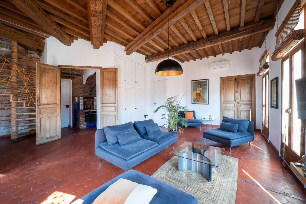 un grand salon avec des meubles bleus et des plafonds en bois dans l'établissement Romantic Getaway in the Heart of Perpignan, à Perpignan