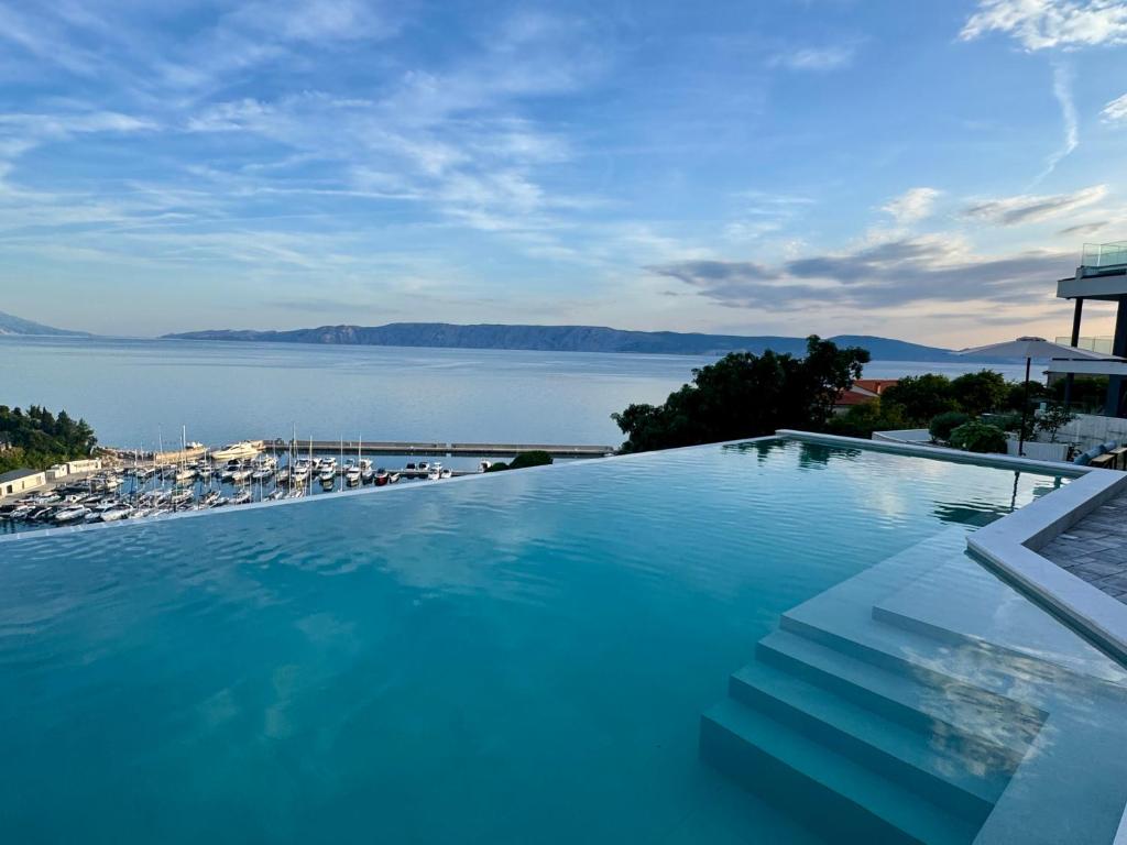 ノヴィ・ヴィノドロスキーにあるDie Appartements Glavas,Eckwohnunge für 2 Personenの水辺の景色を望む大型スイミングプール