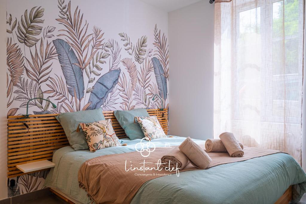 a bedroom with a bed with a tropical wallpaper at Douceur bucolique, jardin & mezzanine cosy in Parigné-lʼÉvêque