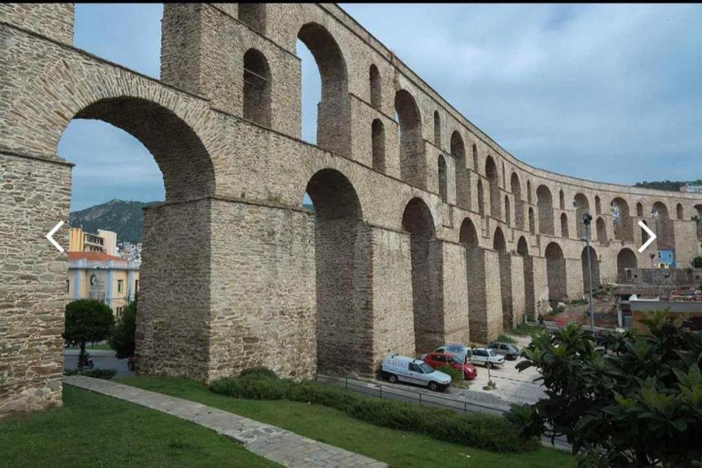 a large stone bridge with cars parked under it at C a M A R E S in Kavala