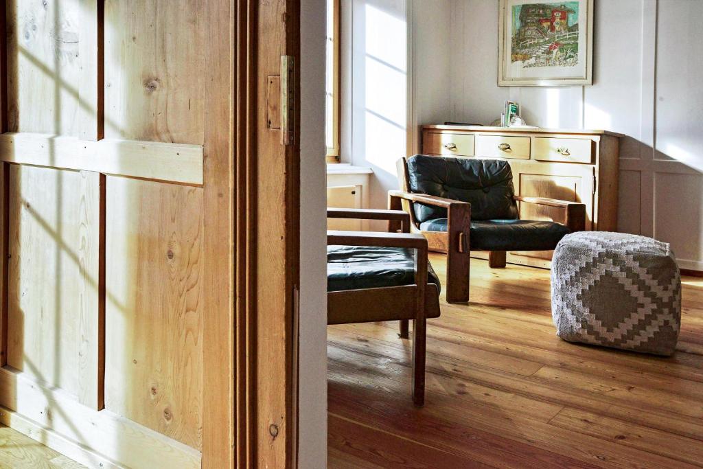 een woonkamer met een bank, een stoel en een tafel bij Grosshus Vals in Vals
