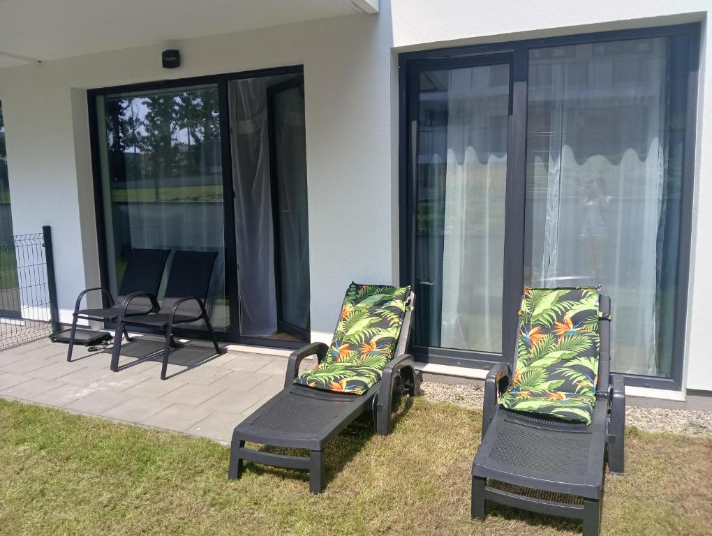 two chairs sitting on a screened in porch at Apartament Fale Bałtyku in Kołobrzeg