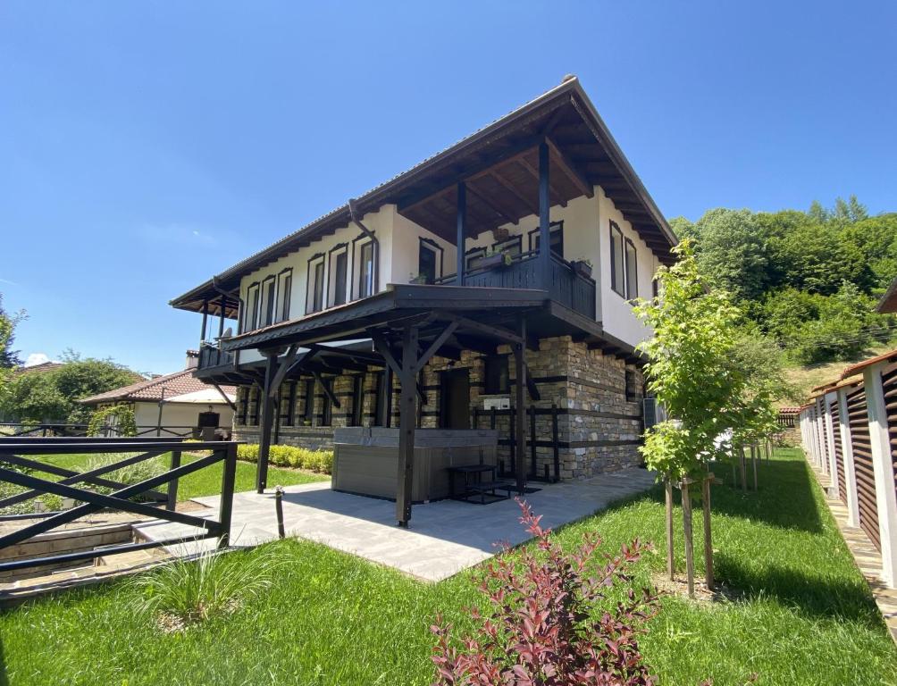 a large house with a gambrel roof at Къща за гости Лъките in Divchovoto