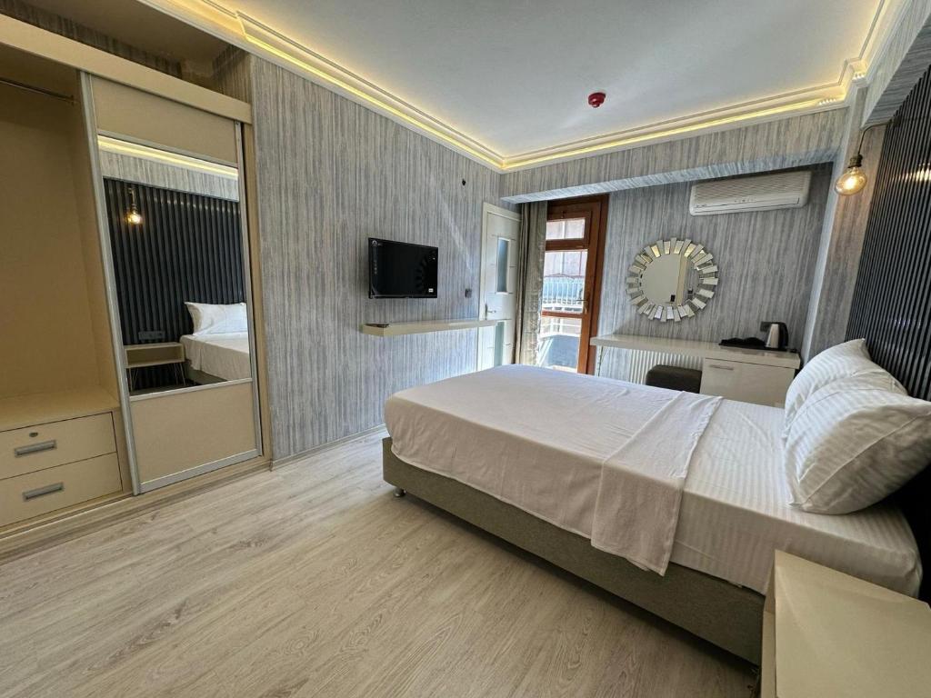 una camera da letto con un letto grande e una televisione di zebra otel buca a Buca