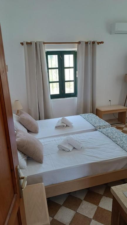 duże łóżko w pokoju z oknem w obiekcie San Marco Guesthouse w mieście Kattavía