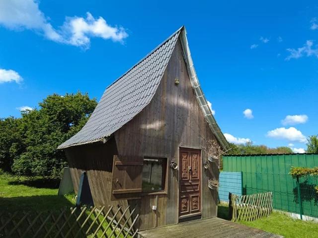 a small wooden house with a pitched roof at La Maison Magique in Trignac