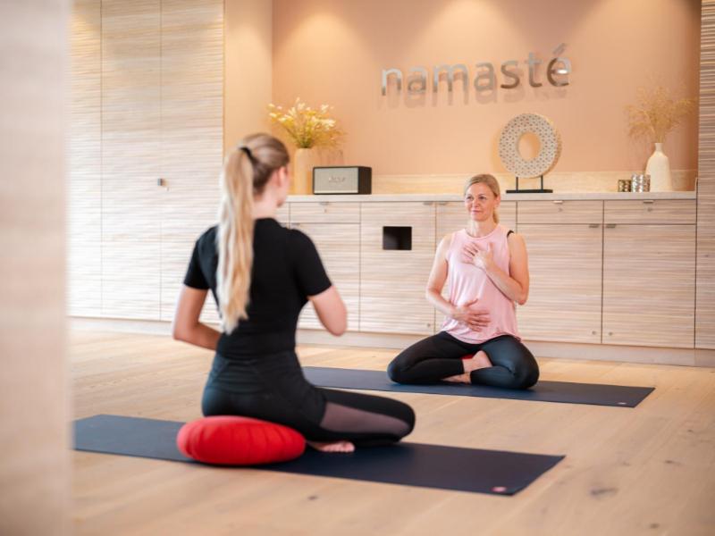 two women sitting in a yoga class with a baby at Grand Tirolia Kitzbühel - Member of Hommage Luxury Hotels Collection in Kitzbühel