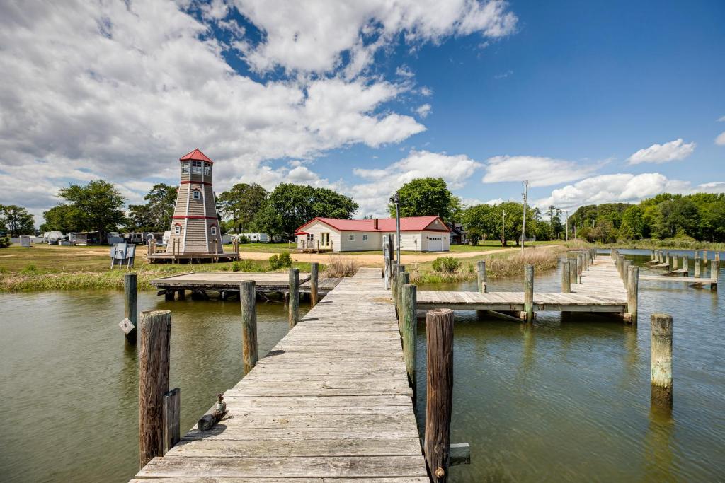a dock with a lighthouse next to a body of water at Sunrise Landing: Waterfront Cottage in Avenue! in Avenue