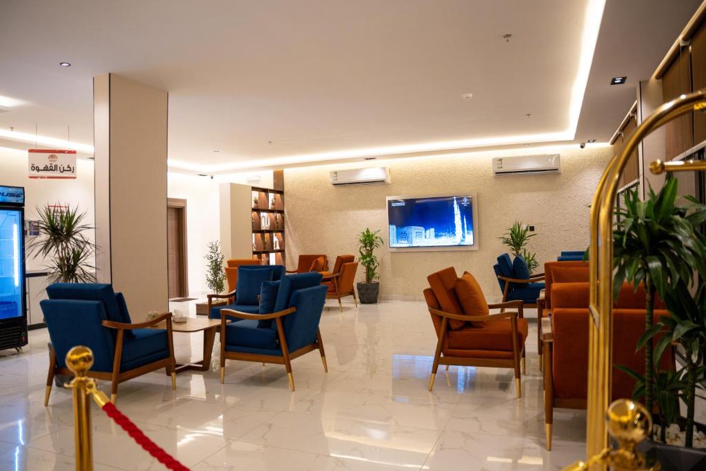 a waiting room with blue chairs and tables in a building at الان للشقق المخدومة in Hail