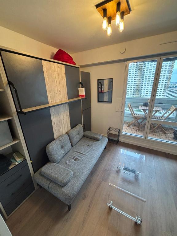 un salon avec un canapé et une grande fenêtre dans l'établissement Studio hyper centre de Rennes, à Rennes