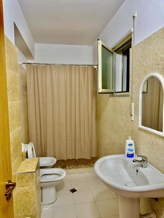 um banheiro com vaso sanitário e pia em Chloe Apartament em Berati