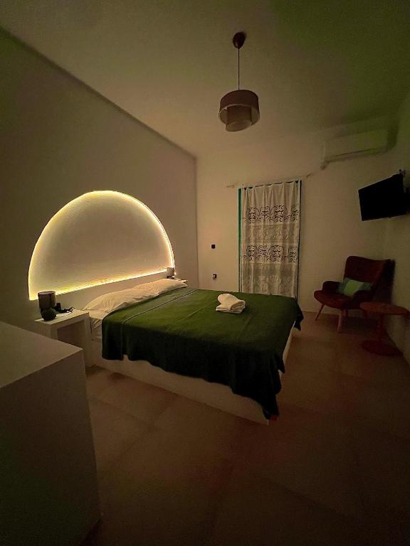 a bedroom with a large bed with an arched window at Nikosgardenplacebythesea in Amorgos