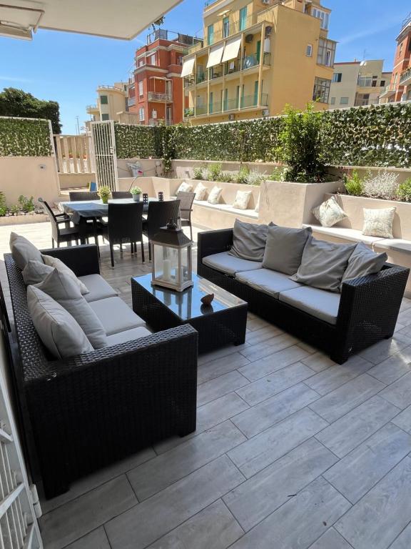 a patio with two couches and a table at Aria di Mare in Lido di Ostia