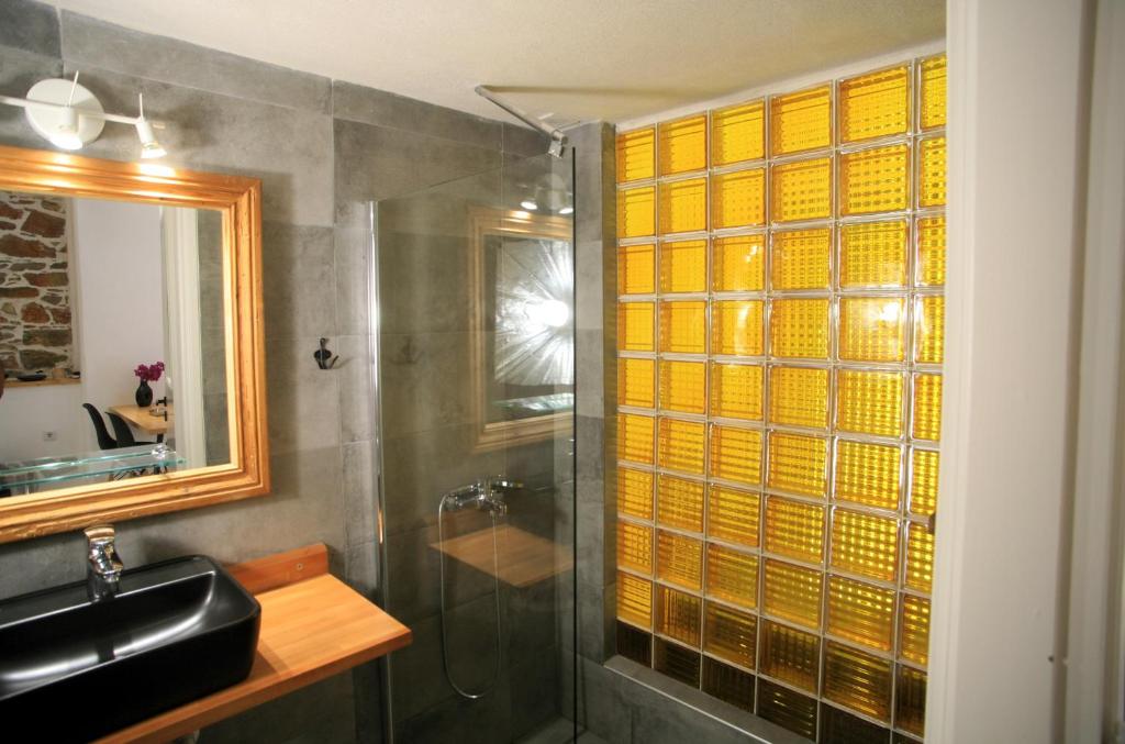 bagno con doccia in vetro e lavandino di Axilleion Boutique Hotel a Ermoupoli