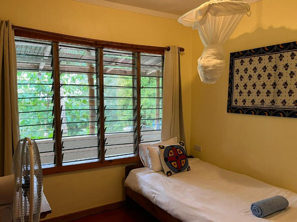 LushotoにあるMilemeleni Lodgeのツインベッド2台と窓のある寝室