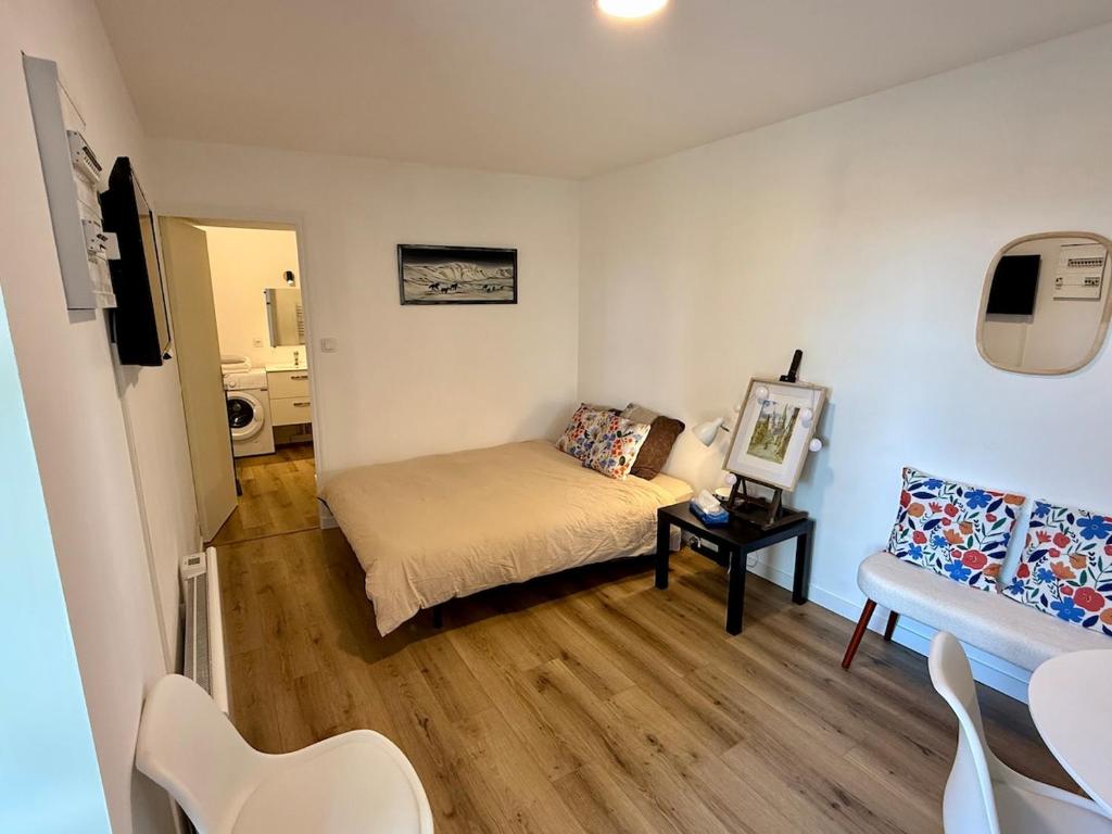 une petite pièce avec un lit et une chaise dans l'établissement Joli Cocon au Cœur de la Petite Cité de Caractère, à La Celle-sous-Gouzon