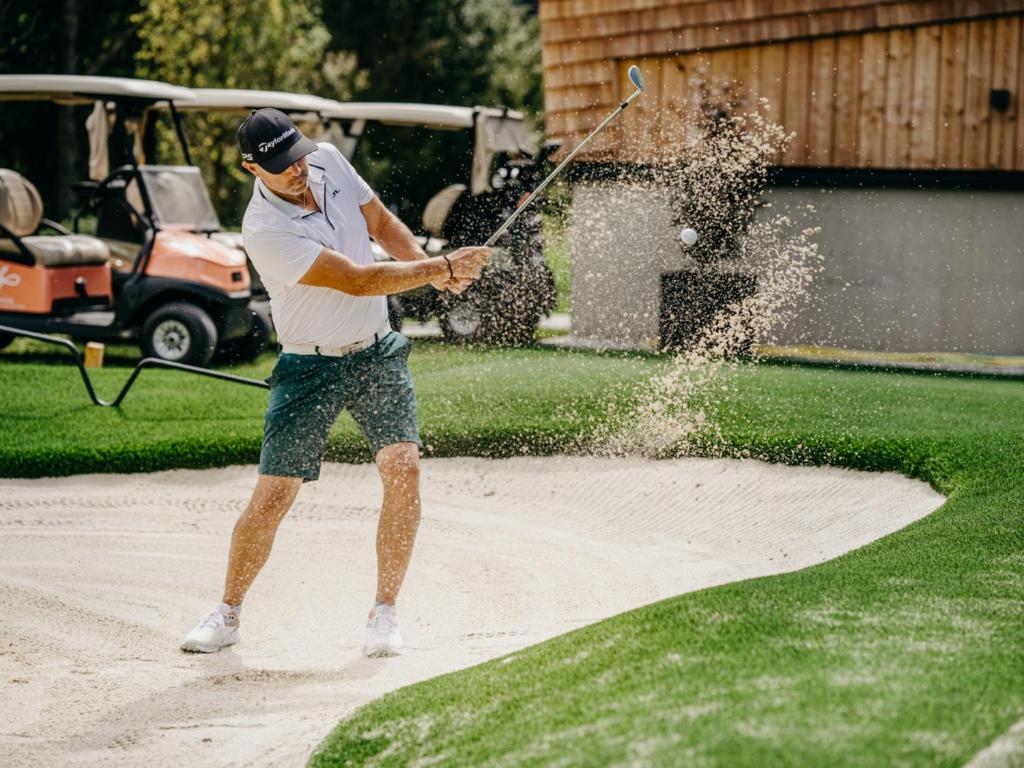 a man hitting a golf ball with a stick at Grand Tirolia Kitzbühel - Member of Hommage Luxury Hotels Collection in Kitzbühel