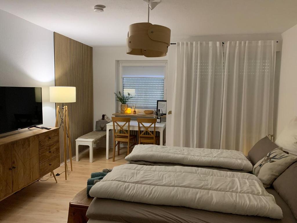 a living room with a bed and a dining room at Schwarzwaldliebe in Schonwald im Schwarzwald