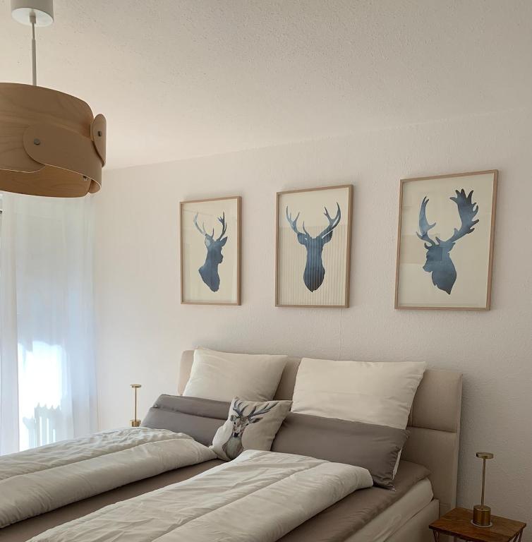a bedroom with a bed with three deer heads on the wall at Schwarzwaldliebe in Schönwald