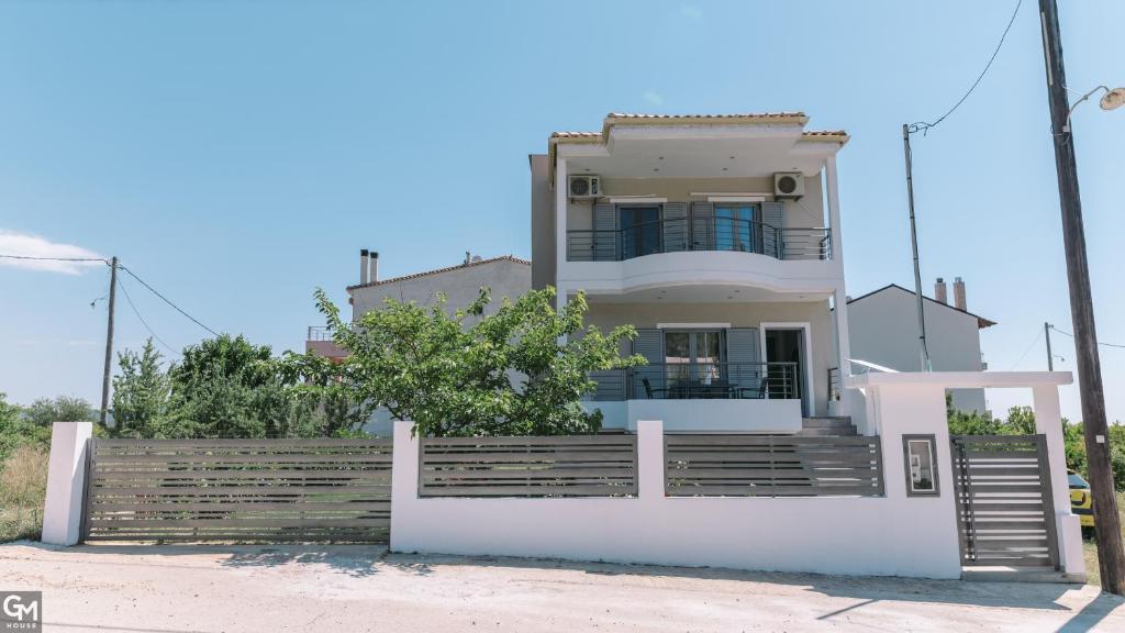 a white house with a fence in front of it at GMhouse in Perdika