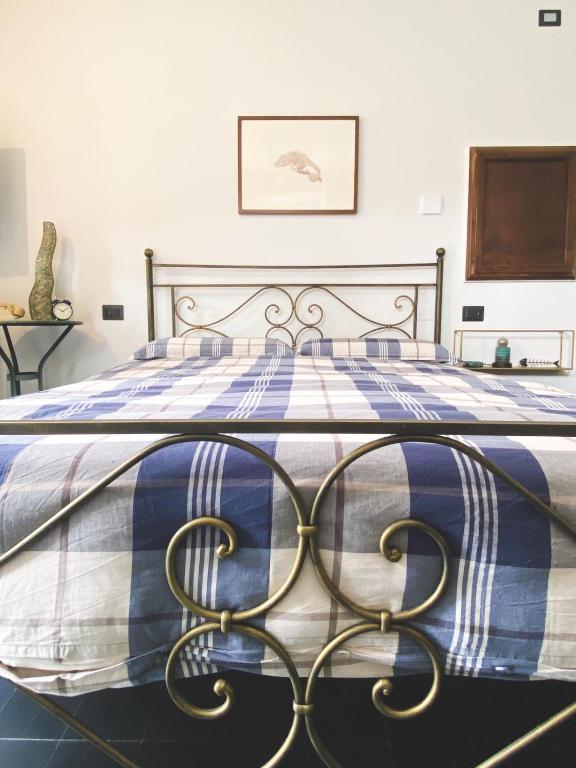 a large bed with a blue and white blanket on it at Residenza Nemus Vinea Mare e Montagna in Graveglia