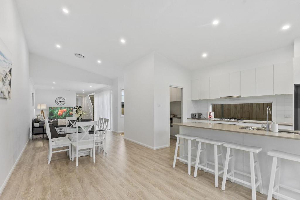 a kitchen and dining room with a table and chairs at Brand New Beach House in The Entrance