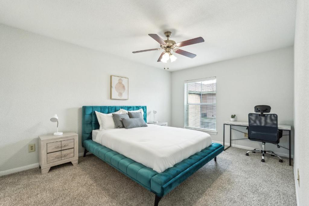 Un dormitorio con una cama azul y un ventilador de techo. en Reserve At Westwood 2300 I Spacious 1 Bed 1 Bath, en Houston