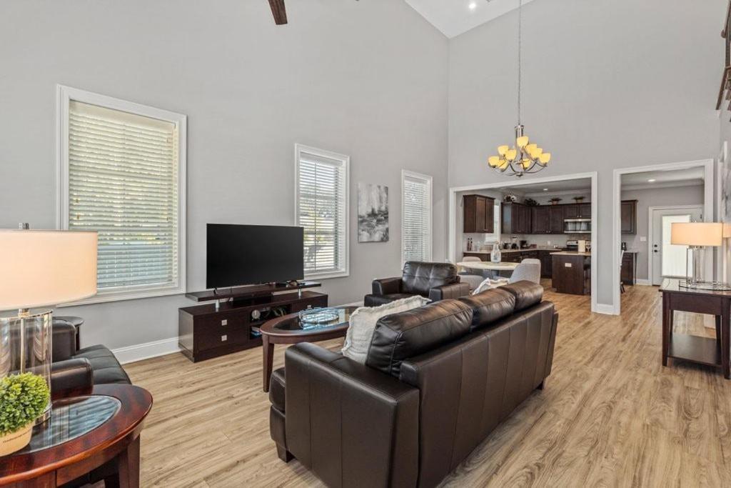 ein Wohnzimmer mit einem Ledersofa und einem TV in der Unterkunft Luxury 2 bedroom townhouse #4 in Lake Charles