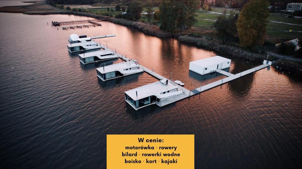 a group of boats docked in the water at Grand HT Houseboats - domki na wodzie - sauna, jacuzzi, kominek in Mielno