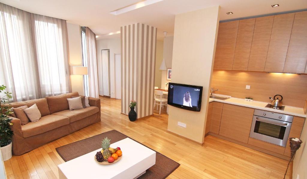 Il comprend un grand salon avec un canapé et une cuisine. dans l'établissement Apartment Centro, à Belgrade