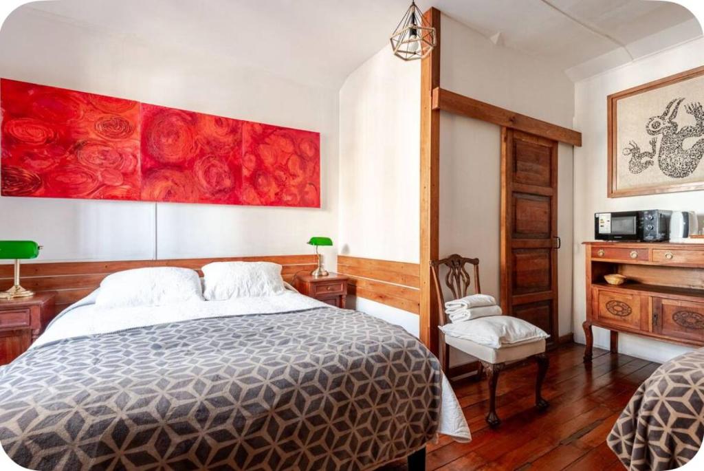 a bedroom with a bed and a red painting on the wall at Studio 522 in Santiago