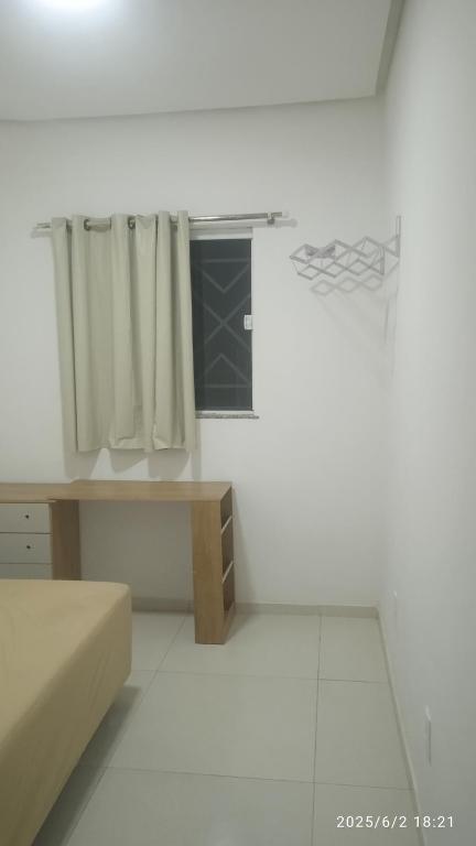 a white room with a bed and a basketball hoop at Kitnet Mobiliada in Vitória da Conquista