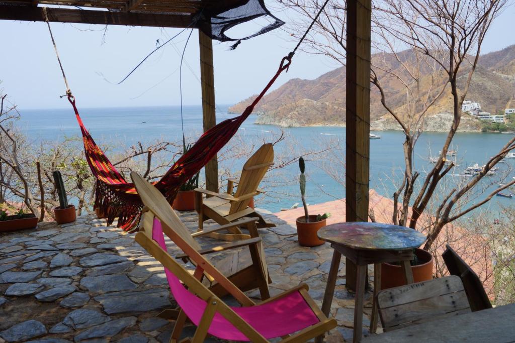 a couple of chairs and a table and a hammock at Hotel Cactus Taganga in Taganga