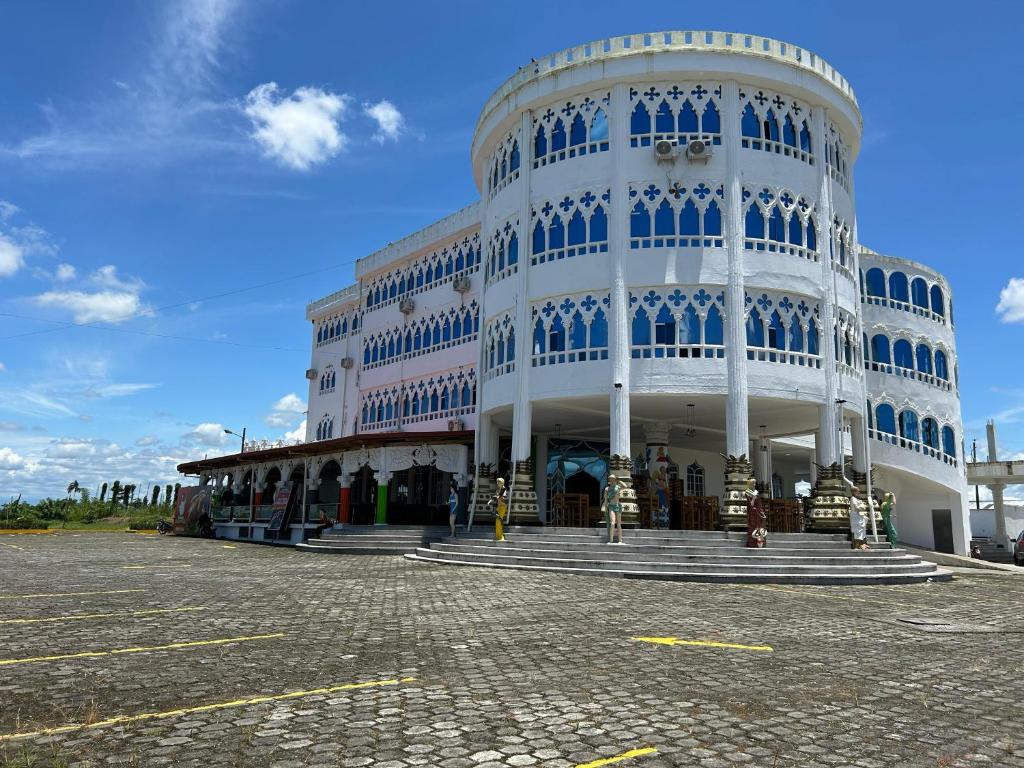 a large white building with blue windows at Hotel Palace in La Concordia
