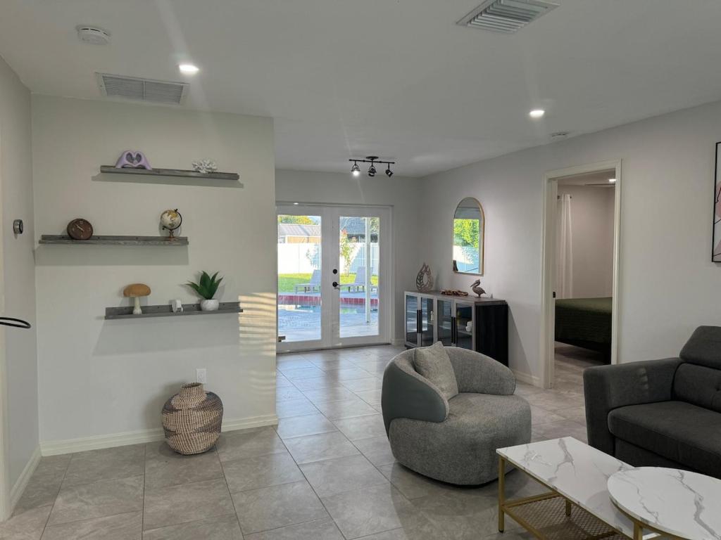 a living room with a couch and a chair at Pool house in Englewood in Englewood