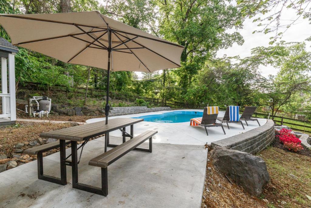 a picnic table with an umbrella next to a pool at Hilltop retreat - Large pool in Woodlawn