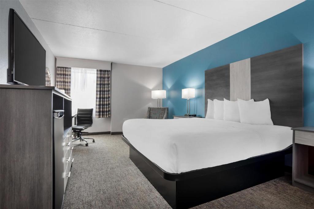 a hotel room with a large bed and a desk at Best Western Brewton Inn in Brewton