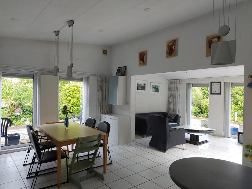 a kitchen and dining room with a table and chairs at Summer house on quiet park close to beach in Ouddorp