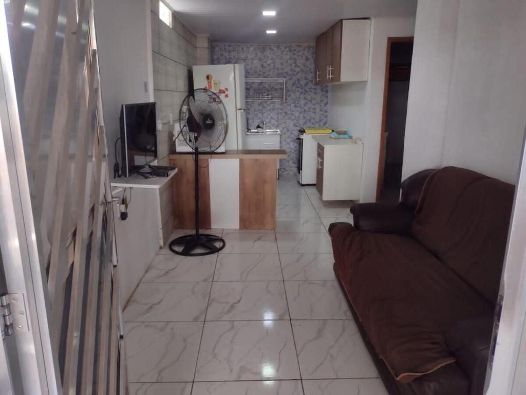 a living room with a couch and a kitchen at Casa com 2 quartos in Rio das Ostras