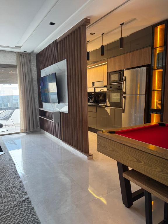 a kitchen with a pool table in a room at Appartement Luxueux Mer & Piscine in Mansouria