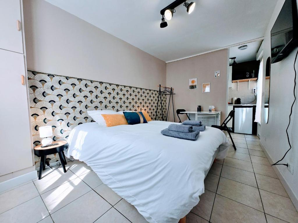 a bedroom with a large white bed in a room at Studio Rez-de-Chausee au Coeur Auxerre in Auxerre