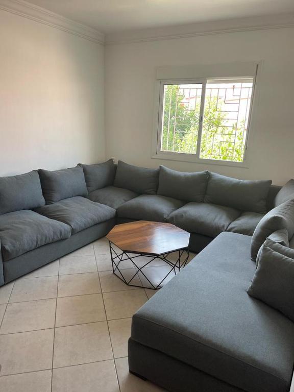 a living room with a couch and a table at Tres belle Appartement situee a martil in Martil