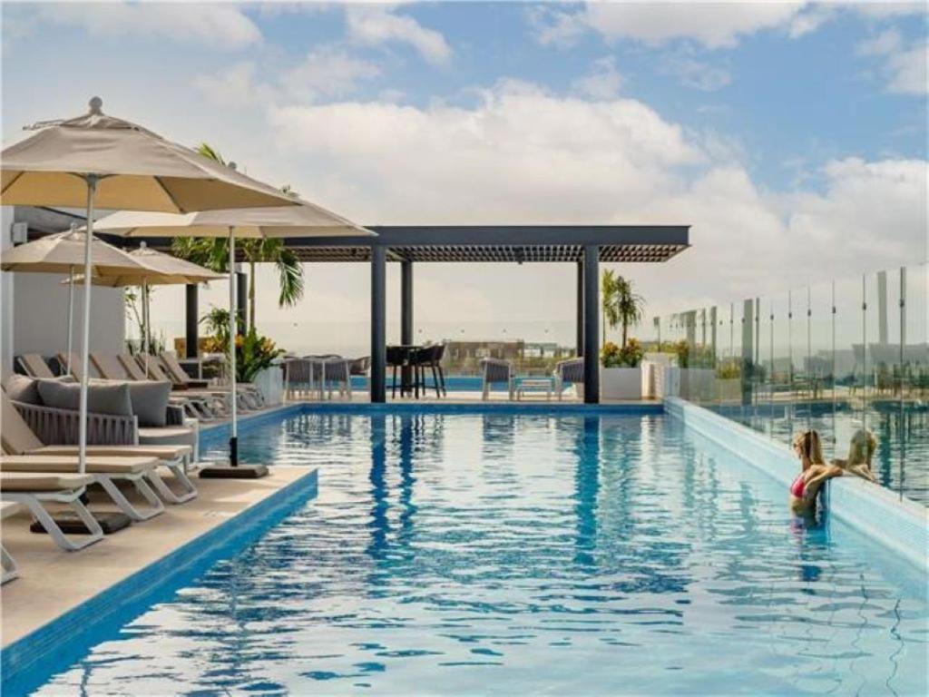 a pool at a hotel with chairs and umbrellas at Serenada Boutique Room Near 5th Ave in Playa del Carmen